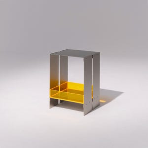 Peut inclure: Une table d'appoint moderne avec un dessus et un cadre gris, avec une étagère jaune vif. La table est de forme rectangulaire et est en métal. Les dimensions sont d'environ 46 cm de haut, 30 cm de large et 30 cm de profondeur.