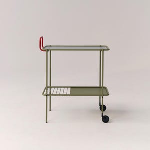 Puede incluir: Carro de servicio de metal verde oliva de dos niveles con asa roja. Tiene estantes rectangulares y una rejilla en la parte inferior. Equipado con ruedas negras para facilitar el movimiento.