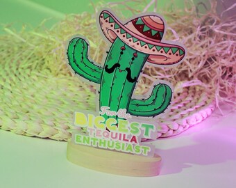 Könnte beinhalten: Ein grüner Kaktus mit einem rosa und roten Sombrero, einem Schnurrbart und dem Text "Für den größten Tequila-Enthusiasten".