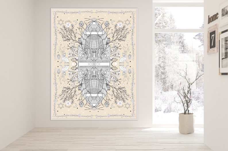 May include: A large, rectangular wall art piece with a cream-colored background. The artwork features a symmetrical black and white illustration of botanical elements, geometric shapes, and celestial motifs. The piece is framed in white and hangs on a white wall.