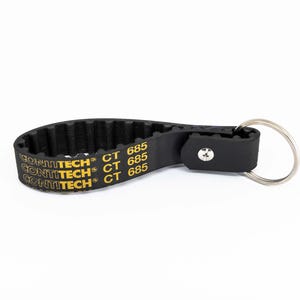 Può includere: Portachiavi nero con una sezione di cinghia scanalata con la scritta "CONTITECH CT 685" in giallo. Il portachiavi ha un cinturino in pelle nera e un portachiavi argentato.