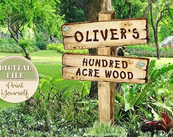 Puede incluir: Un letrero de madera con el texto "Oliver's Hundred Acre Wood" en una fuente rústica. El letrero está pintado de marrón y tiene un aspecto desgastado. Hay dos abejas con alas y cuerpos amarillos en el letrero.