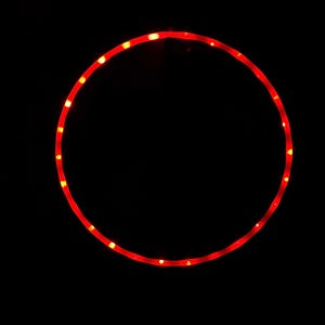 Puede incluir: Una tira de luz LED roja en forma de círculo, brillando intensamente sobre un fondo negro.