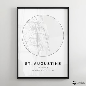 Könnte beinhalten: Schwarz-weiß-Kartenabdruck von St. Augustine, Florida. Die Karte befindet sich in einem Kreis mit dem Städtenamen und den Koordinaten darunter. Der Druck ist in einem schwarzen Rahmen gerahmt.