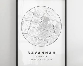 Könnte beinhalten: Ein Schwarzweiß-Kartenabdruck von Savannah, Georgia. Die Karte ist in einem Kreis und der Name der Stadt und die Koordinaten sind unter der Karte gedruckt. Der Druck ist in einem schwarzen Rahmen gerahmt.