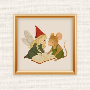 May include: Cross-stitch art of a fairy and a mouse reading a book. The fairy wears a red hat and green dress, while the mouse wears green overalls. The artwork is framed in a gold-colored frame.