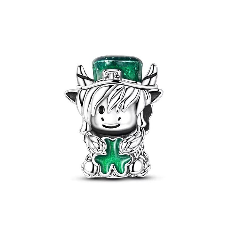 May include: A silver charm featuring a cartoon-style figure with a green top hat and a green shamrock. The figure has white hair and is holding a green shamrock. The charm is likely for a bracelet or necklace.