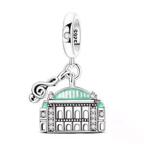 May include: A silver charm with a building design, featuring a mint green roof and sparkling accents. A treble clef and the text "S925" are also visible.