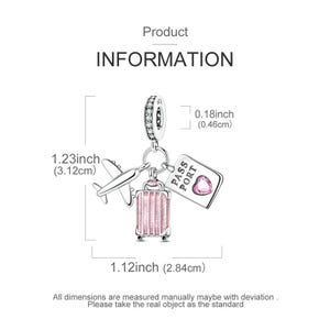 May include: A silver charm with travel-themed pendants. The charm includes a small airplane, a pink suitcase, and a passport with a heart. The charm is 1.23 inches (3.12 cm) long, 1.12 inches (2.84 cm) wide, and 0.18 inches (0.46 cm) thick.