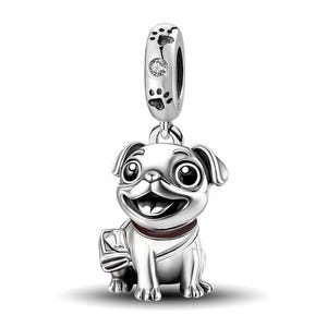 May include: A silver charm depicting a smiling pug dog with large eyes and a brown collar. The charm has a paw print design on the top loop and a small gem. A cute dog-themed jewellery piece.