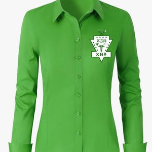 May include: A bright green long-sleeve button-down shirt featuring a white shield-shaped emblem on the left chest. The emblem displays a handshake, a caduceus, and the Greek letters XHΦ. The shirt has a classic collar and buttoned cuffs.