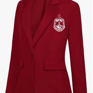 May include: A burgundy blazer with a single-button closure, a notched lapel, and a breast pocket. The blazer features a white emblem on the chest and the text "MNT LMT" on the label.