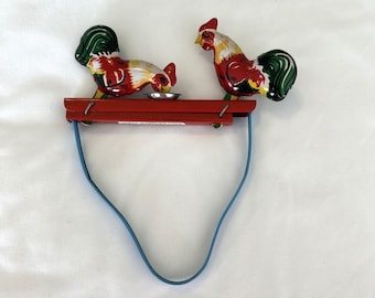 Gallos picoteando de hojalata litografiada estilo vintage, juguete mecánico de apretar, pájaro rojo y verde