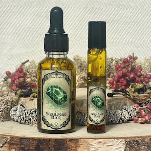 Pode incluir: Duas garrafas de Elixir de Oasis Esmeralda, uma em uma garrafa conta-gotas e outra em uma garrafa de rolo. Ambas as garrafas est&atilde;o cheias de um l&iacute;quido transparente e t&ecirc;m um r&oacute;tulo verde com uma imagem de uma gema verde e o texto "Elixir de Oasis Esmeralda".