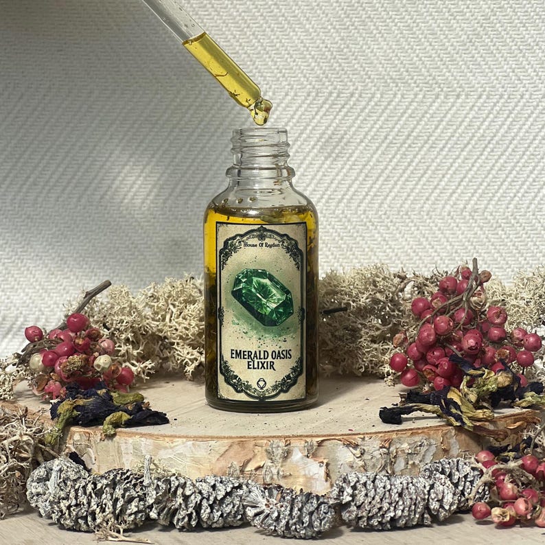 Pode incluir: Uma garrafa de vidro com um r&oacute;tulo dourado que diz "Emerald Oasis Elixir". A garrafa est&aacute; cheia de um l&iacute;quido transparente e um conta-gotas est&aacute; dispensando uma gota de l&iacute;quido da garrafa. A garrafa est&aacute; sentada sobre uma superf&iacute;cie de madeira com musgo e bagas.