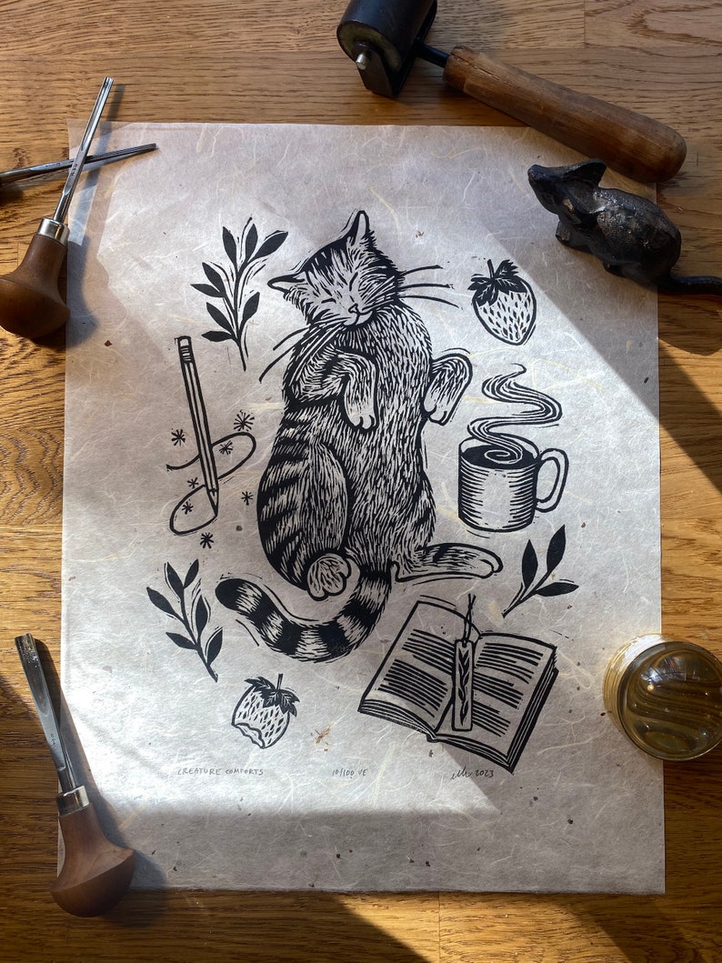 Le confort des créatures Linogravure en relief d'un chat avec du café et un livre Natural Chiri