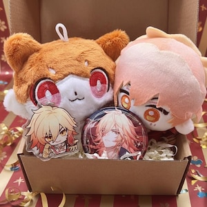 May include: A brown cardboard box filled with plush toys and character merchandise. The box contains two plushies, a button, and an acrylic charm. The plushies are orange and white. The button and charm feature a male anime character.