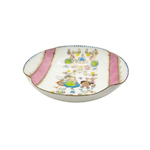 Pode incluir: Um prato decorativo oval branco com listras rosa e acabamento dourado. O prato apresenta uma ilustração colorida de figuras e padrões florais. A borda tem uma borda azul ondulada. Uma peça decorativa vintage.