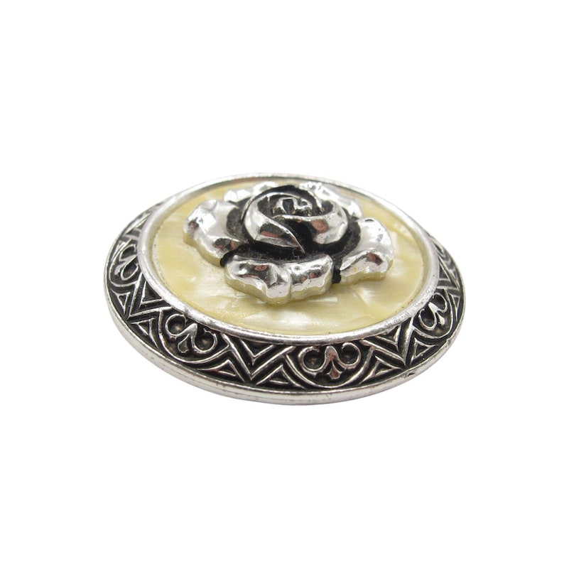 Mid century West Germany scarf clip featuring raised rose design and ornate metal border