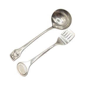 Può includere: Un set di mestolo e forchetta in argento. Il mestolo ha una ciotola rotonda e un lungo manico. La forchetta ha una testa rettangolare con quattro rebbi e un lungo manico. Il manico del mestolo ha un motivo floreale.