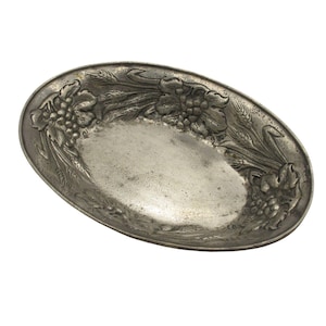 Puede incluir: Un plato de servir ovalado de plata con un diseño en relieve de trigo y uvas alrededor del borde.