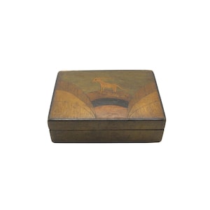 May include: A wooden box with a decorative lid. The lid features a tan-colored animal silhouette on a landscape design with shades of brown and green. The box is rectangular and has a dark brown frame.