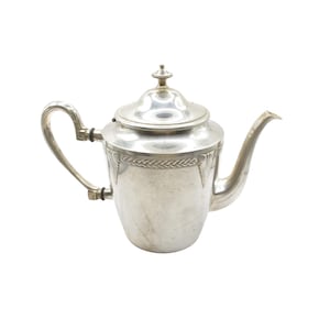 Può includere: Una teiera d'argento con manico e beccuccio curvi. La teiera ha un coperchio con un piccolo pomello e una fascia decorativa intorno al centro. La teiera è realizzata in metallo lucido ed è posta su uno sfondo bianco.