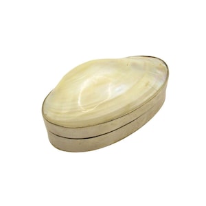 May include: A small oval-shaped trinket box made of mother of pearl with a silver rim.