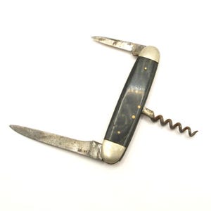 Op de afbeelding: Een vintage zakmes met een zwart handvat en twee messen. Het mes heeft ook een kurkentrekker.