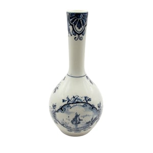 Puede incluir: Un jarrón de cerámica blanco con cuerpo bulboso y cuello largo y delgado. Está decorado con diseños florales y paisajísticos azules, incluyendo una escena con un velero. El borde del jarrón presenta un patrón azul detallado.