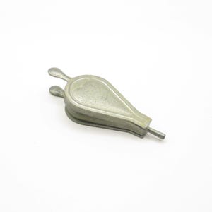 May include: A silver-coloured metal bellows, used for creating a stream of air. The bellows has a teardrop shape with a handle and two small, rounded handles on top. The object is likely used for starting fires.