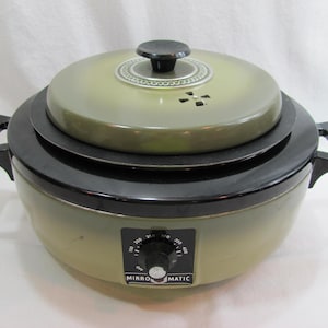 May include: A green and black Mirro-Matic electric roaster with a round lid and a temperature control knob. The roaster has two handles and a black base.