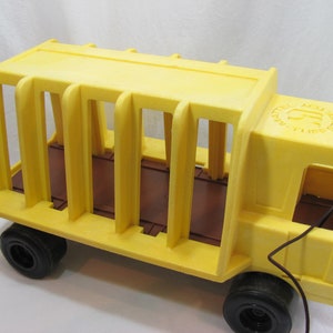 May include: Yellow plastic toy truck with a cage on the back. The truck has black wheels and a brown floor. The truck has a Mattel logo on the side.