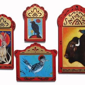 May include: Four framed, hand-painted illustrations of animals. The frames are red with gold accents. The illustrations depict a jackrabbit, a crow, a roadrunner, and a bison with a bluebird perched on its back.
