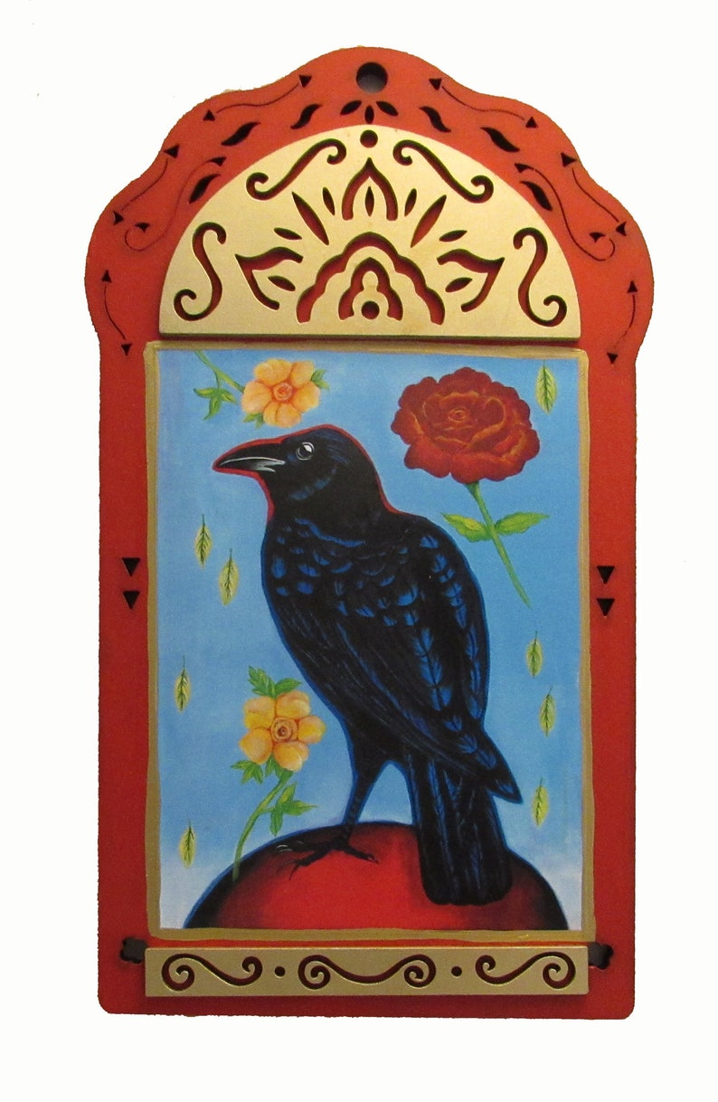 May include: A black raven perched on a red orb, surrounded by yellow and red flowers. The raven is depicted in a folk art style with a blue background. The image is framed in a red and gold wooden frame with intricate carvings.
