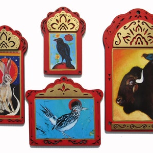 May include: Four framed, hand-painted illustrations of animals. The frames are red with gold accents. The illustrations depict a jackrabbit, a crow, a roadrunner, and a bison with a bluebird perched on its back.