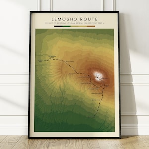 May include: A framed topographic map print titled Lemosho Route, displaying a mountain landscape in shades of green, yellow, and brown. The map features a dotted black trail line, various camp labels, and elevation data at the top in black text.