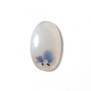 Op de afbeelding: Een witte ovale agaat cabochon met een dendritisch patroon in tinten blauw en zwart.