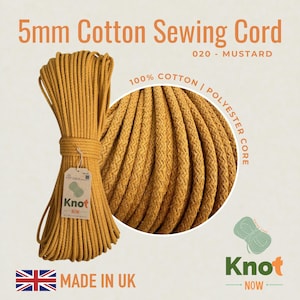 Puede incluir: Cordón de costura de algodón de 5 mm color mostaza. La imagen muestra un rollo de cordón con una etiqueta que dice "Knot Now" y "Made in UK". El cordón es 100% algodón con un núcleo de poliéster. El color está etiquetado como "020 - MUSTARD".