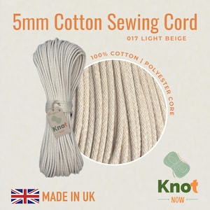 Op de afbeelding: Een bundel van 5 mm lichtbeige katoenen naaikoord, met een polyester kern. De afbeelding bevat een close-up van de textuur van het koord en de tekst "100% Cotton | Polyester Core". Het product is gelabeld "Made in UK".