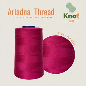 May include: A large spool of fuchsia polyester thread labeled Ariadna Thread and Knot Now. The text includes Color Palette- Polyester 5000M and T026- Fuchsia. The thread is wound in a cross-hatch pattern on a cylindrical spool with a dark top.