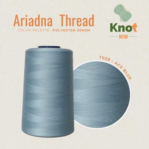May include: A large spool of Ariadna polyester thread in Ace Blue, labeled T028. The text reads Ariadna Thread, Color Palette- Polyester 5000M, and Knot Now. The thread is a solid, muted light blue color with a smooth, tightly wound texture.