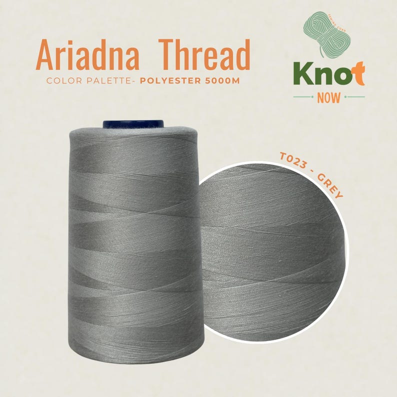 May include: A large spool of grey Ariadna polyester thread labeled T023 - GREY. The spool contains 5000M of thread. The image includes the text Ariadna Thread, COLOR PALETTE- POLYESTER 5000M, and the Knot NOW logo with a green yarn icon.