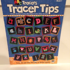 May include: A blue and white "Tracer Tips" book with colorful alphabet letters and numbers. The cover features the text "Tracer Tips" and "Trace, Cut and Glue Your Way to Perfect Letters!"