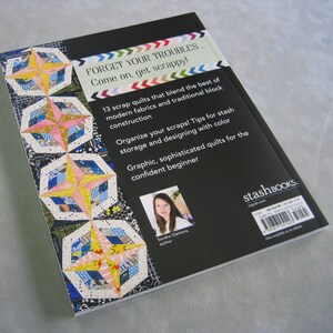 May include: Book cover with a black background and a colorful quilt design. The title is "Forget Your Troubles... Come on, get scrappy!" and the subtitle is "13 scrap quilts that blend the best of modern fabrics and traditional block construction". The author is Sandra Clemons.