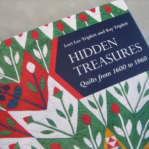 May include: Book cover with a blue background and the title "HIDDEN TREASURES Quilts from 1600 to 1860" in white text. The cover features a colorful quilt pattern with red, green, and white.