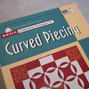 May include: A book titled "Your First Quilt Book: Basic Quiltmaking Techniques for Curved Piecing" with a red, white, and gold quilt pattern on the cover.
