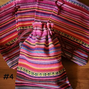 K&ouml;nnte beinhalten: Eine Sammlung farbenfroher, gestreifter Stoffbeutel mit Kordelzug und passenden Stoffst&uuml;cken. Die Beutel und der Stoff weisen ein lebhaftes Muster aus rosa, roten, blauen, gelben und gr&uuml;nen horizontalen Streifen auf. Die Nummer "#4" ist links unten in Wei&szlig; aufgedruckt.