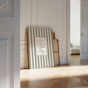 Może przedstawiać: Oprawione dzieło sztuki z pionowym wzorem w szare i białe paski, oparte o ścianę. Grafika zawiera tekst "Meet Me On The Green" w stylu ręcznym. Pok&oacute;j ma parkiet i białe ściany.