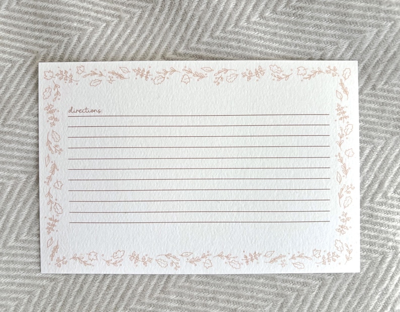 May include: A blank recipe card with a floral border in a light pink color. The card has lines for writing directions and the word "directions" is written at the top.